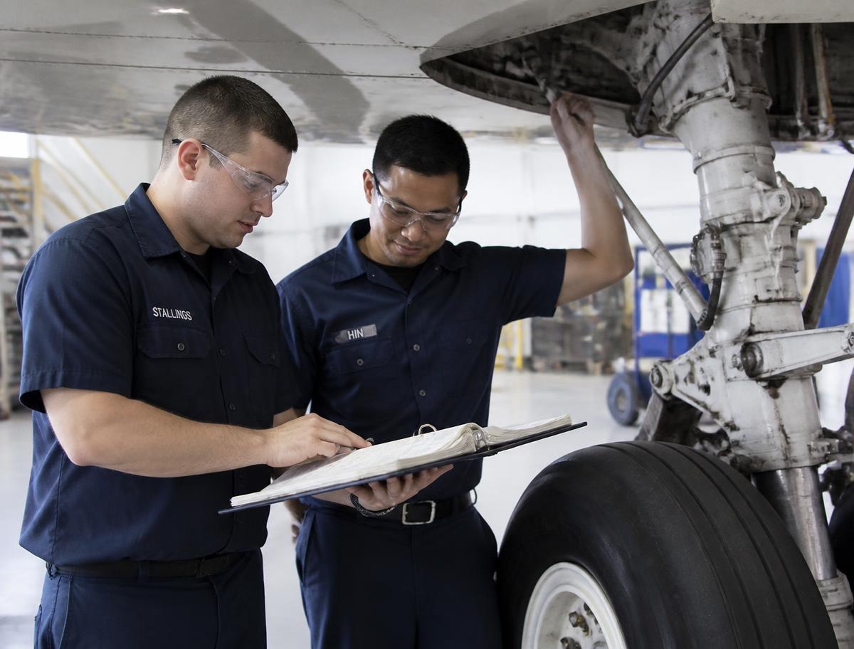 Up North Aero technicians reviewing a maintenance logbook